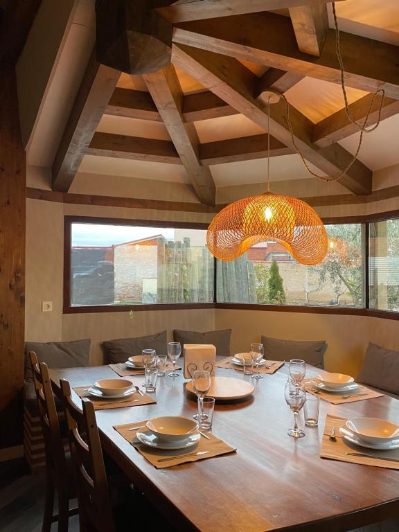 a dining room with a large wooden table with glasses at Las Gavias in Matapozuelos