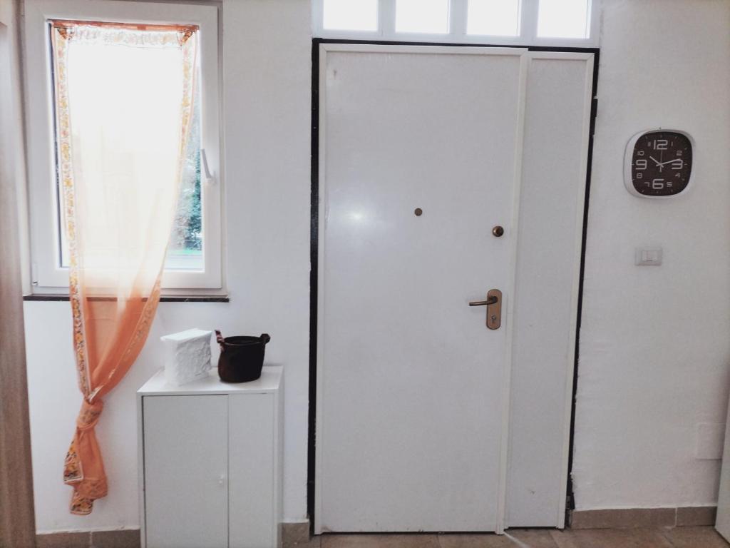 Una puerta blanca en una habitación con ventana en Mini liquirizia e menta en Reggio Emilia