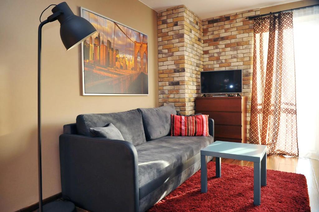 a living room with a gray couch and a table at Apartament Numer 5 in Ustrzyki Dolne