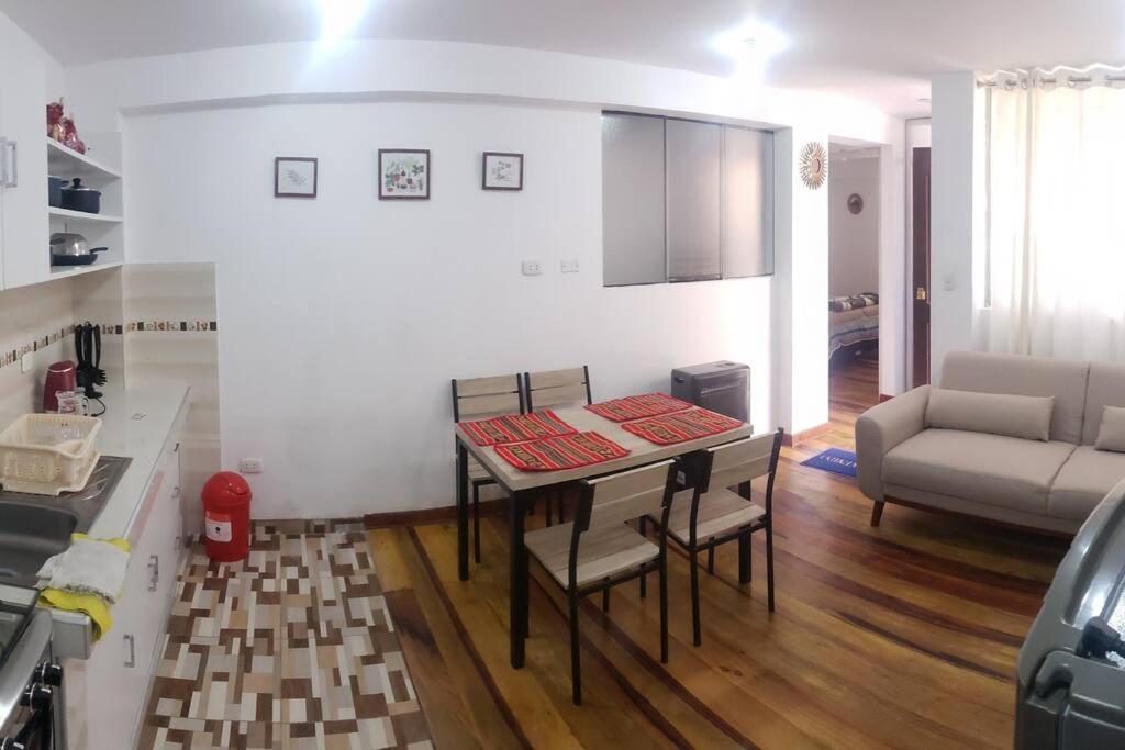 a kitchen and living room with a table and chairs at Cusco Central Aparment in Cusco