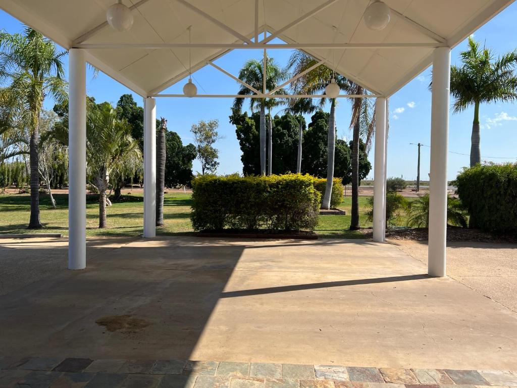 a white pavilion with palm trees in a park at Albert Park Motor Inn - Oil Friendly Price in Longreach