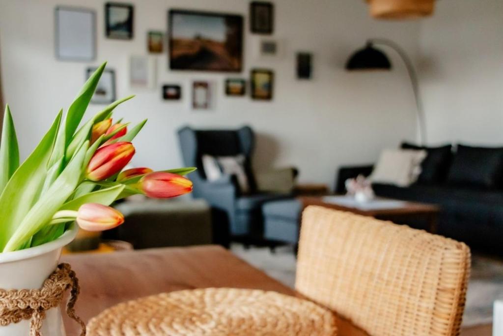 una sala de estar con una mesa con un jarrón de flores en See Land Luft, en Warnitz