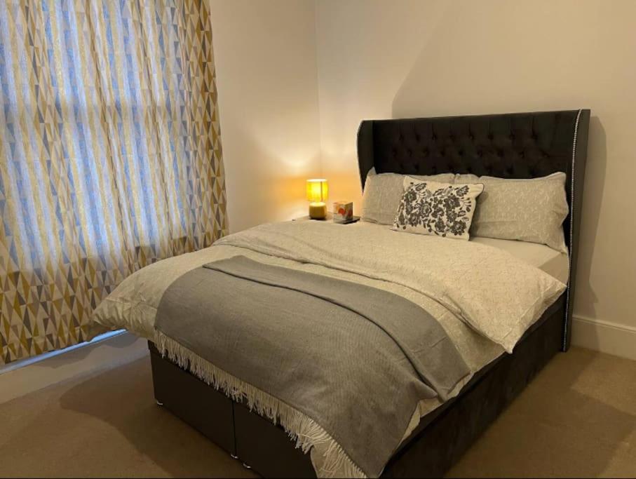 a bedroom with a large bed with a lamp on it at Two Bedroom Flat in London in London