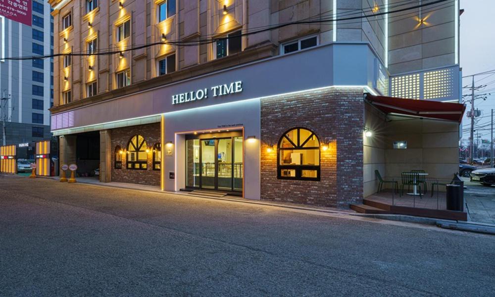 un bâtiment avec un panneau horaire d'hôtel dans une rue dans l'établissement Gumi time hotel, à Gumi