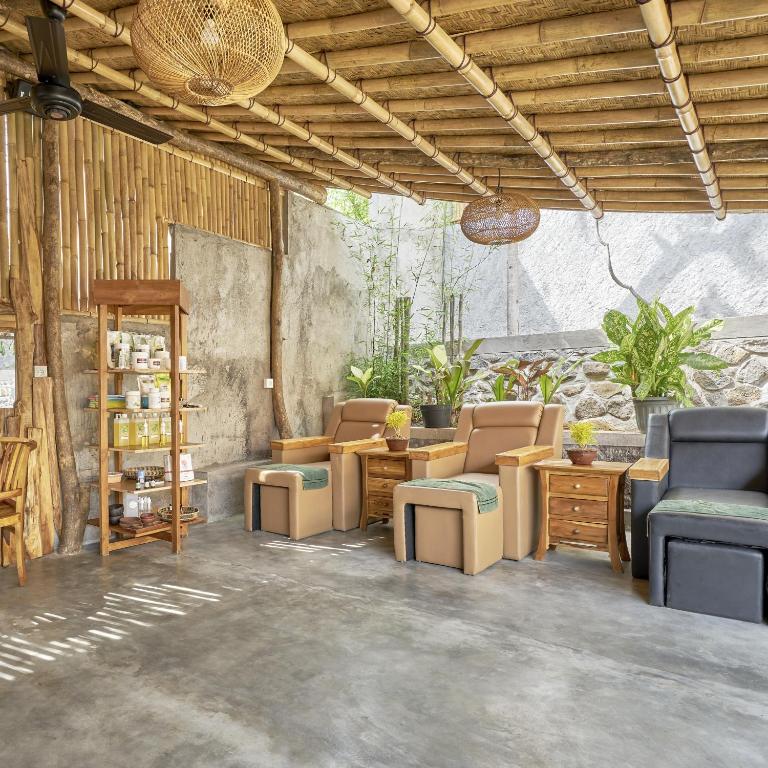 a living room with chairs and a table and a shelf at Anda Amed Villas & Spa in Amed