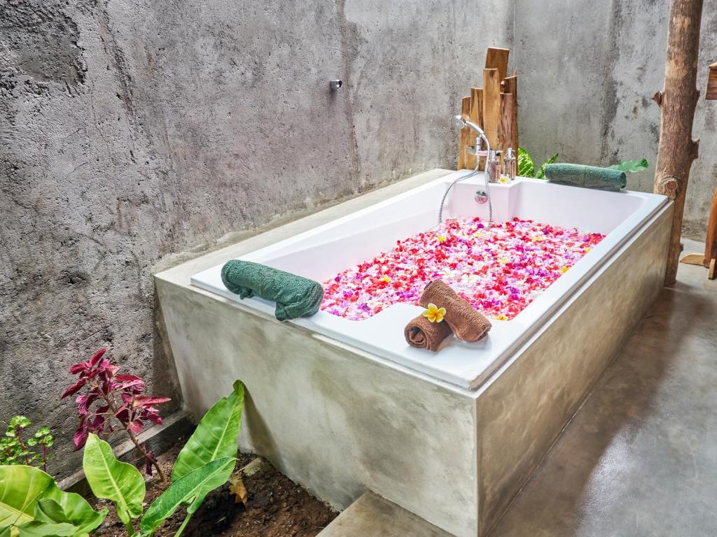 a bath tub filled with sprinkles in a bathroom at Anda Amed Villas & Spa in Amed