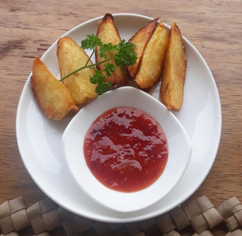 a plate of food with a bowl of dipping sauce at Anda Amed Villas & Spa in Amed