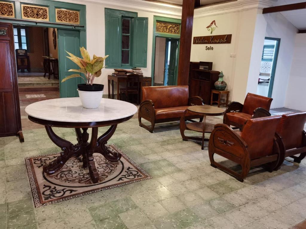 un soggiorno con tavolo e sedie di Ndalem Kinasih Homestay Syariah a Solo