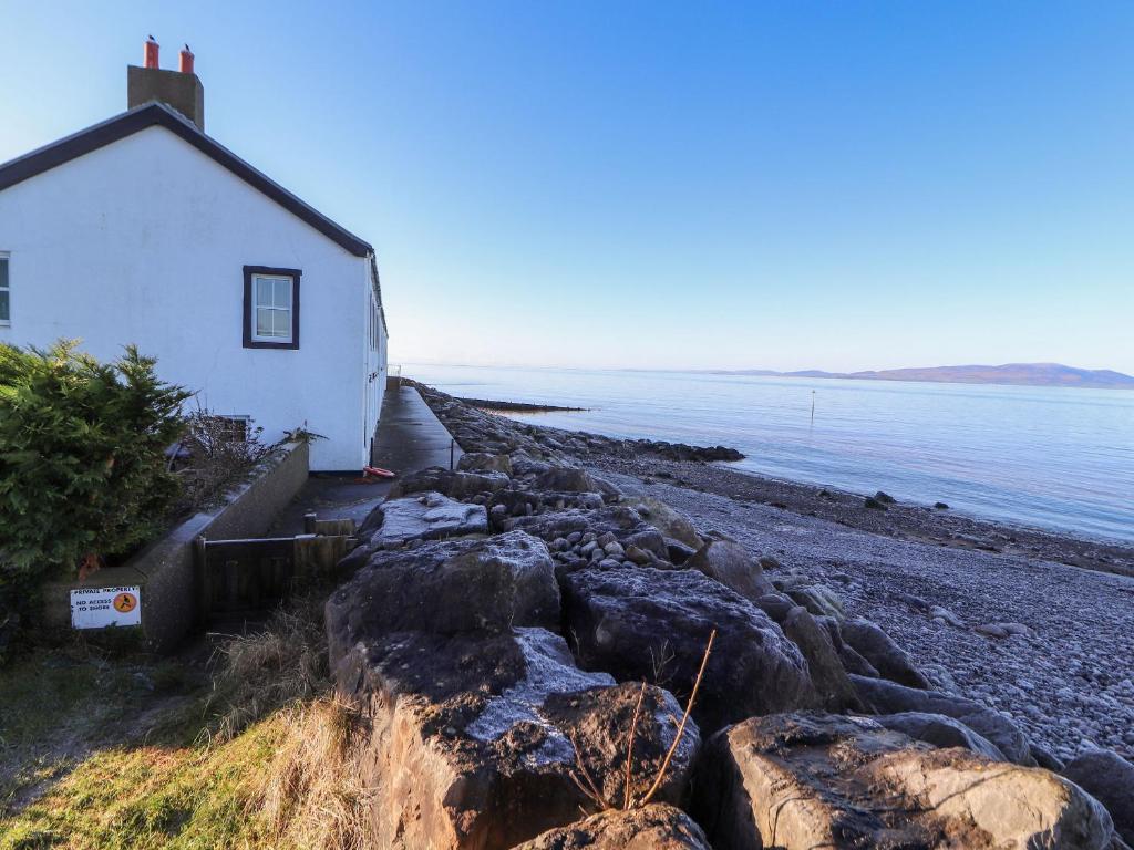 a house on the shore of a rocky beach at Greenmantle in Skinburness