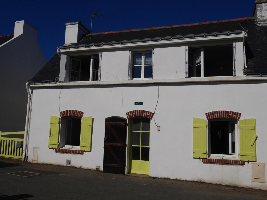 un edificio blanco con persianas amarillas y verdes en Maison Sauzon, 4 pièces, 6 personnes - FR-1-418-211 en Sauzon