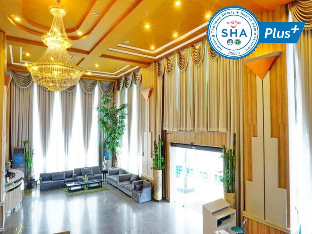 a lobby of a hotel with couches and a chandelier at Bay Hotel Srinakarin in Bangna