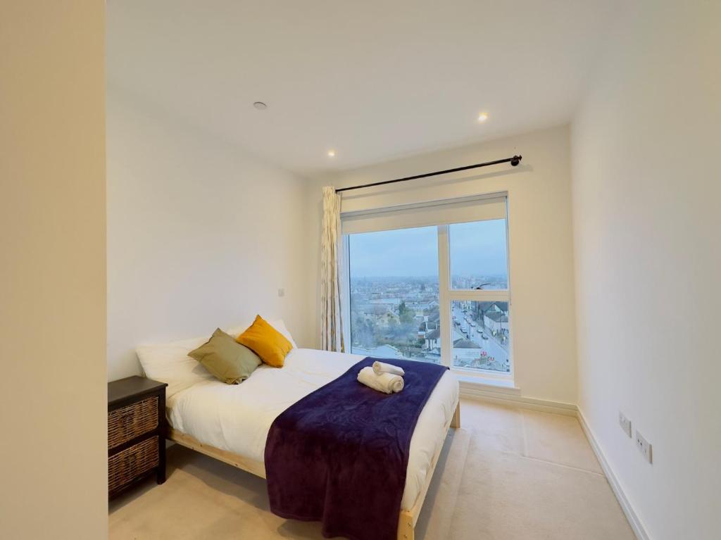 a bedroom with a bed and a large window at Luxurious Comfy Penthouse - Steps to East Croydon Train Station - Views in Croydon