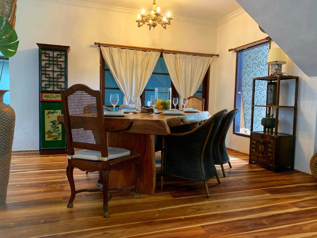House near Seminyak 6BR promo في كيروبوكان: غرفة طعام مع طاولة وكراسي خشبية
