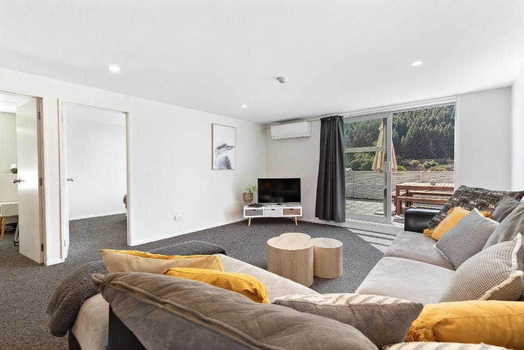 a living room with a couch and a tv at Central Mountain View Paradise in Queenstown