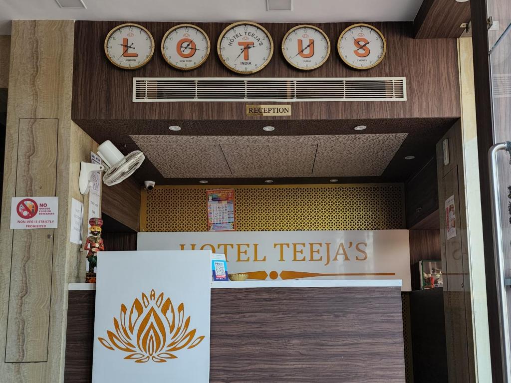 a building with clocks on the wall above a door at Hotel Teeja's - Haldi Restaurant Aiims road Jodhpur in Jodhpur