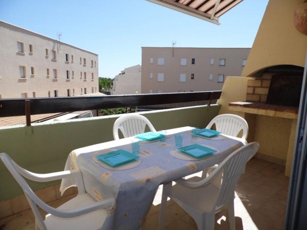 une table blanche et des chaises sur un balcon dans l'établissement Studio cabine mezzanine 6 pers, terrasse, barbecue, parking privé - Marseillan-Plage - FR-1-326-403, à Marseillan