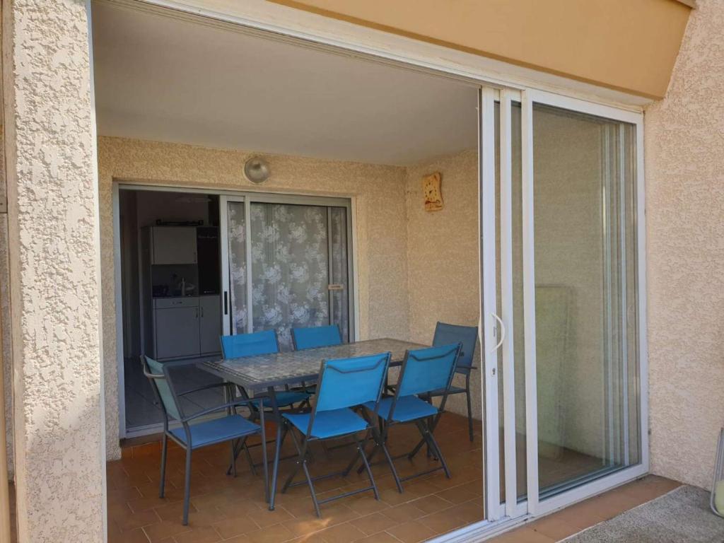 une salle à manger avec une table et des chaises bleues dans l'établissement Appartement Marseillan-Plage, 2 pièces, 6 personnes - FR-1-326-643, à Marseillan