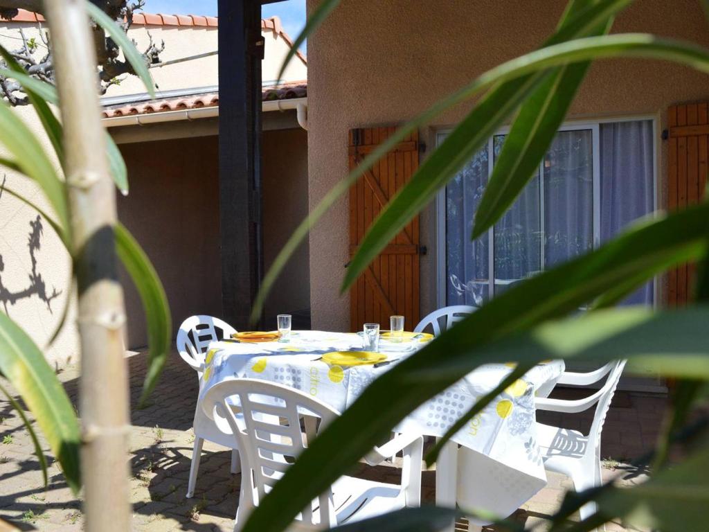 une table et des chaises assises sur une terrasse avec une table et des chaises dans l'établissement Charmant pavillon à 300m de la plage, 3 pièces, mezzanine, terrasse, 4 couchages - Saint Pierre La Mer - FR-1-229D-83, à Fleury