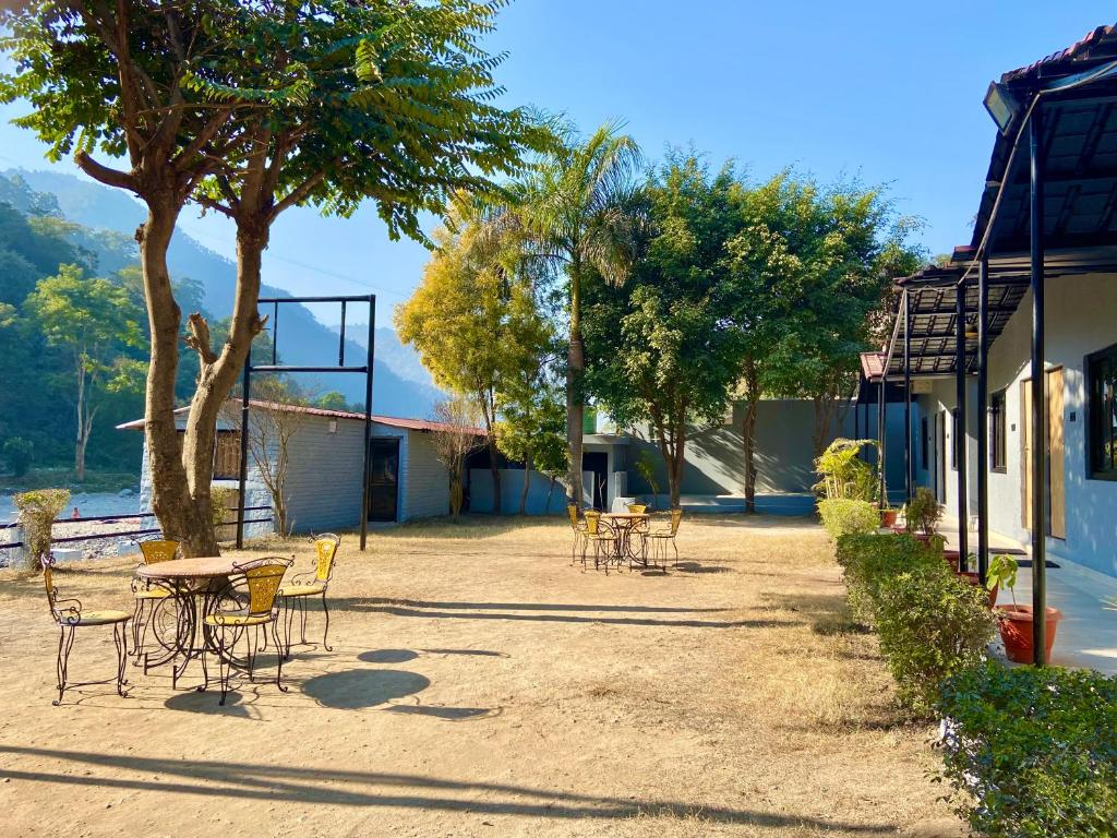 a group of tables and chairs next to a building at Euphoric River Resort in Rishīkesh