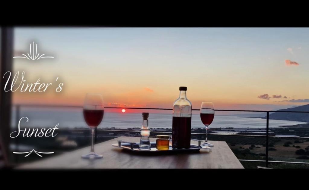 stół z 2 kieliszkami i butelką wina w obiekcie Casa di Olive, all seasons accommodation w mieście Goúdhouros