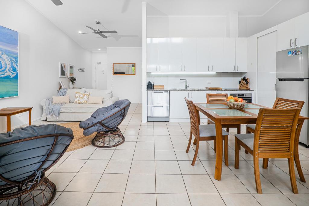 a kitchen and living room with a table and chairs at Rainbow Shores - 2 Bedroom, modern apartment, sleeps 6, pool, walk to the beach in Rainbow Beach