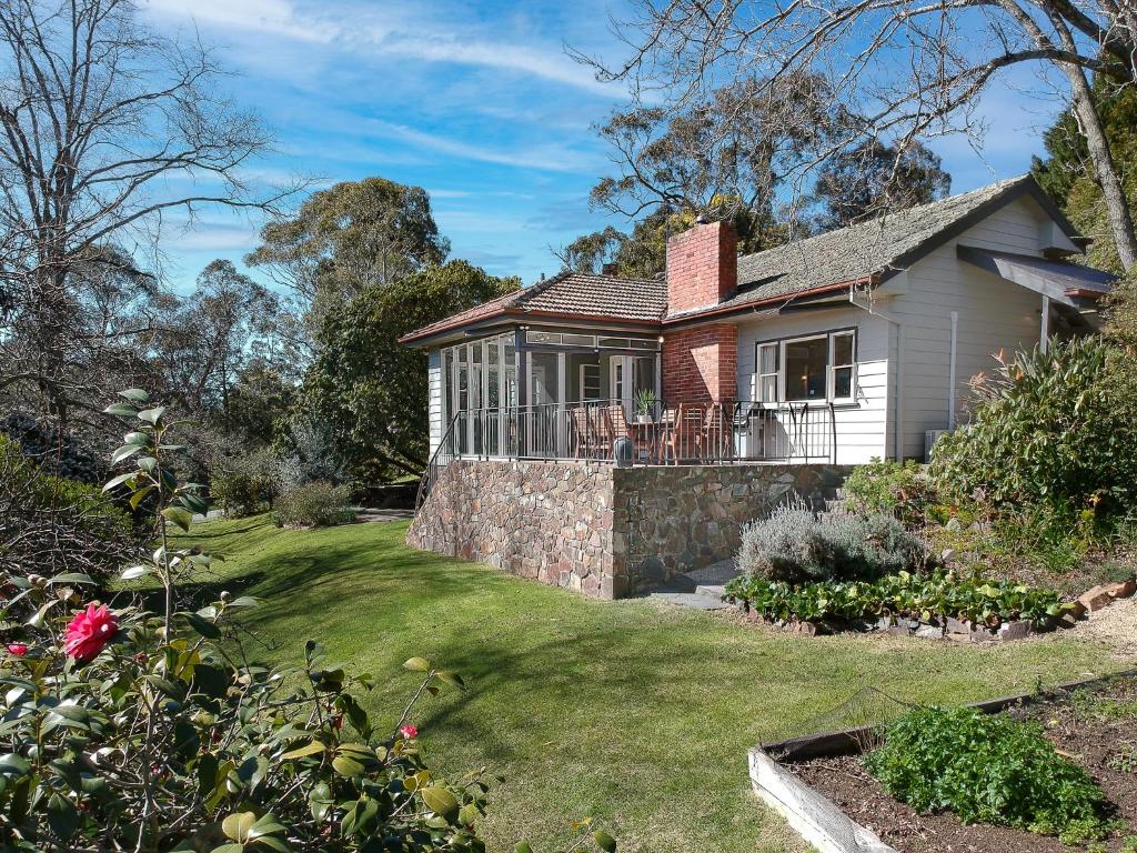 a small white house with a stone wall at Mi Casa - Healesville in Healesville