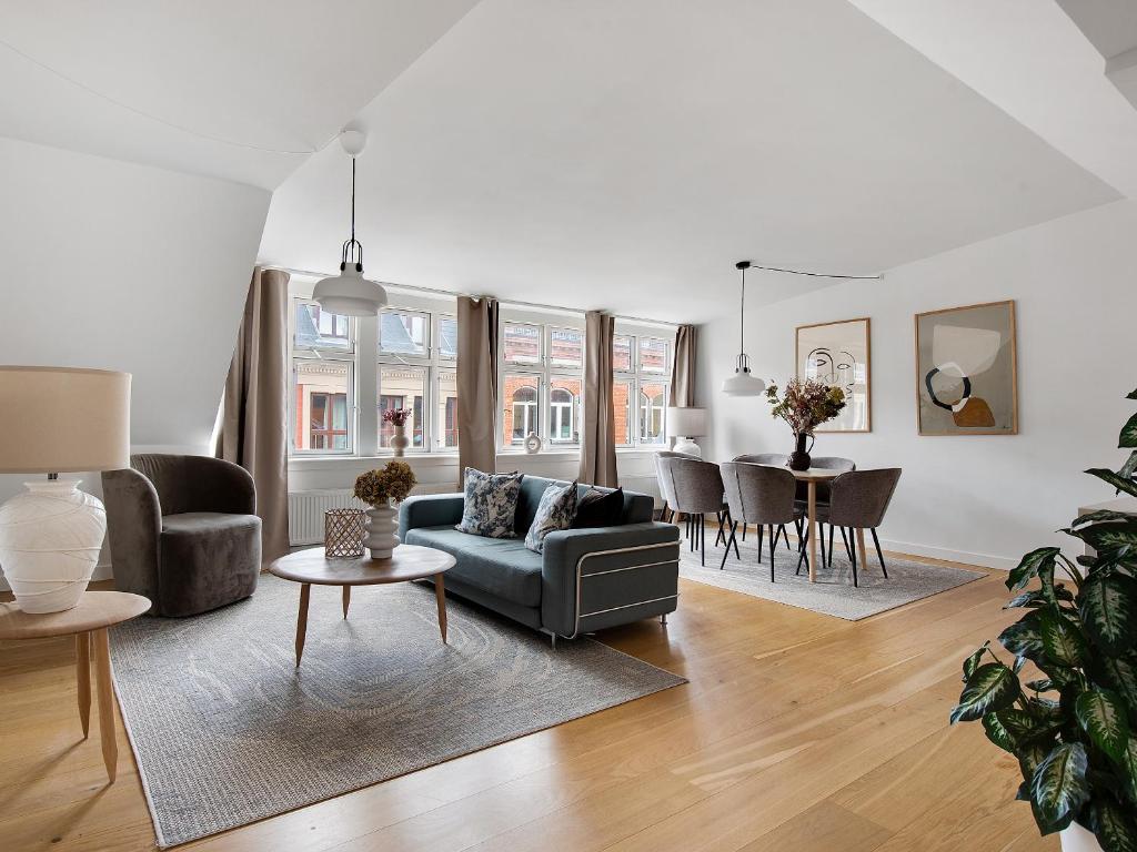 a living room with a couch and a table at Sanders Leaves - Precious Two-Bedroom Penthouse In Downtown Copenhagen in Copenhagen