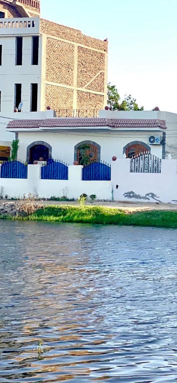 a white building next to a body of water at Villa Victoria Old Nile View in Luxor