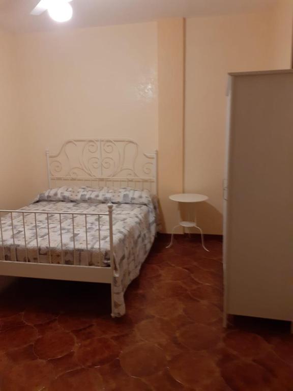 Un dormitorio con una cama y una mesa. en Idea Vacanze Musso - Struttura 1, en Ravanusa