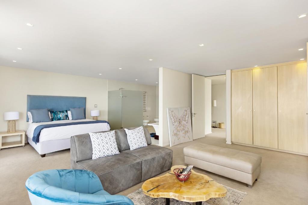 a living room with a couch and a bed at Cape Blue in Cape Town