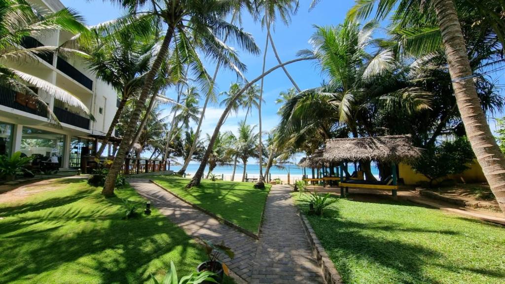 a walkway to the beach in front of a resort at Dickwella Beach in Dickwella
