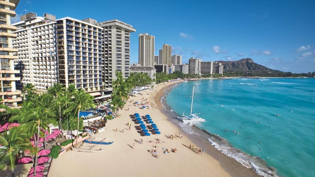 eine Luftansicht auf einen Strand mit Menschen und Gebäuden in der Unterkunft OUTRIGGER Waikiki Beach Resort in Honolulu