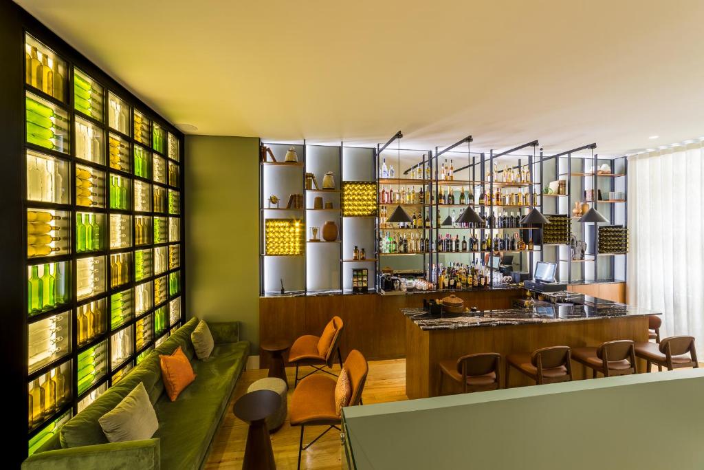 un bar en un restaurante con una pared verde en Gallery Hostel, en Oporto