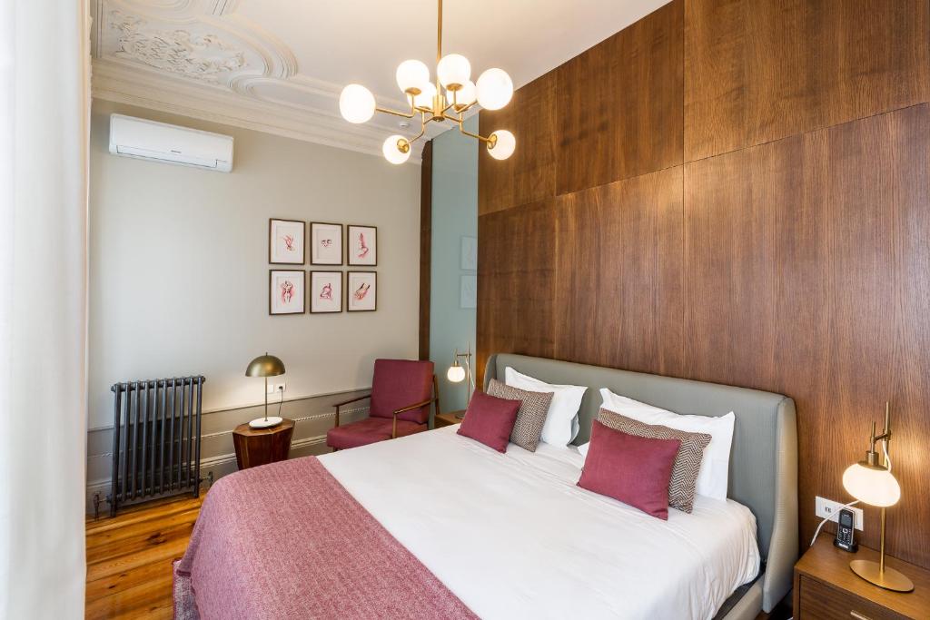 una camera con un grande letto e una parete in legno di Gallery Townhouse & Home a Porto