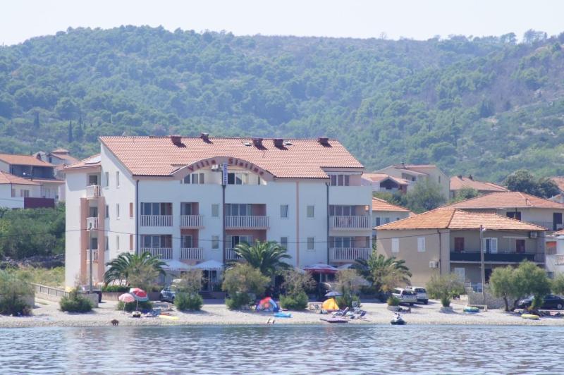 a large building on a beach next to the water at Vila Slatine - Beach Apartments in Slatine