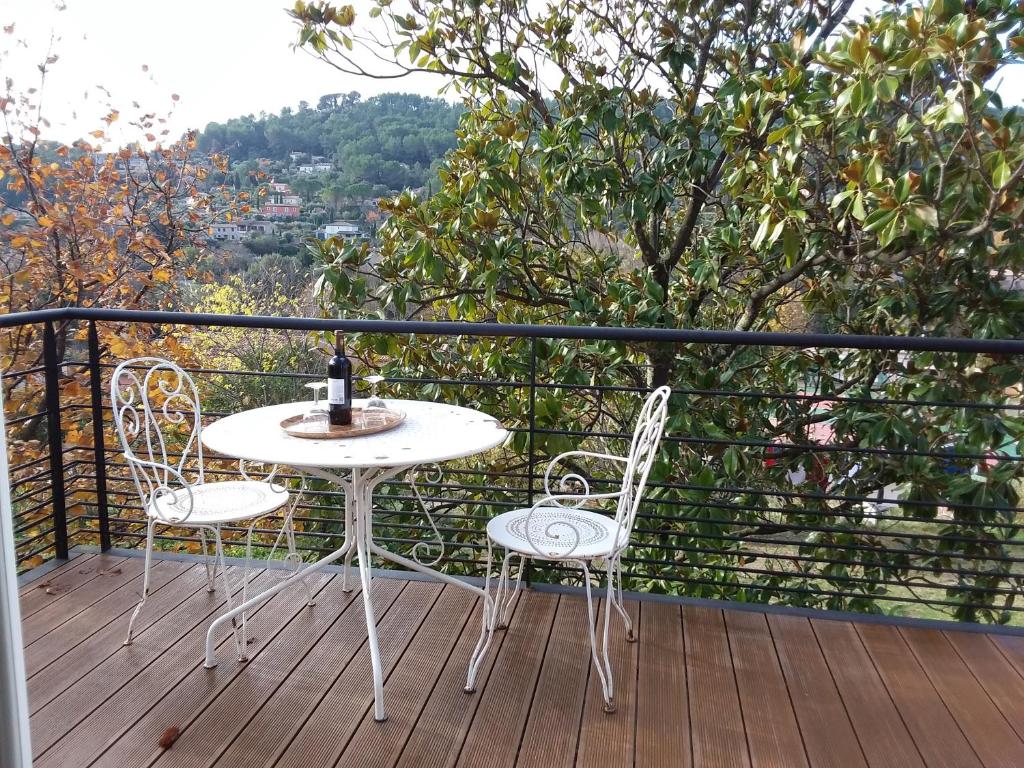 uma mesa branca e 2 cadeiras numa varanda em L'Autre Maison em Cotignac