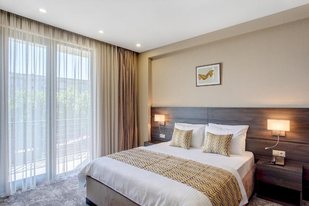 a hotel room with a bed and a large window at Vinum Hotel in Tbilisi City
