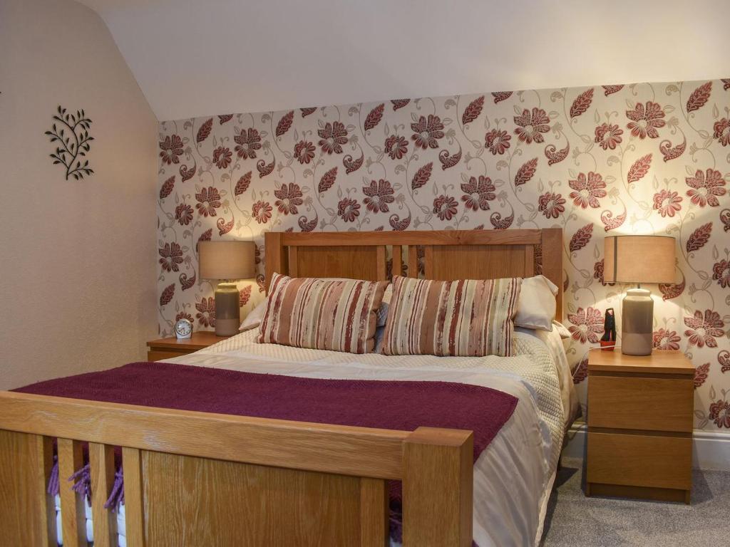 ein Schlafzimmer mit einem großen Bett mit zwei Nachttischen in der Unterkunft Wards Court 1 - Uk41270 in Cirencester
