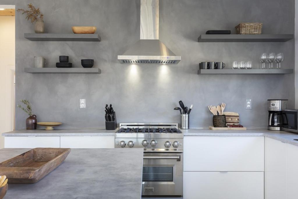 een keuken met witte kasten en een fornuis met oven bij Rock Box - Modern Adobe Nestled in the Boulders Above Coyote Hol home in Joshua Tree