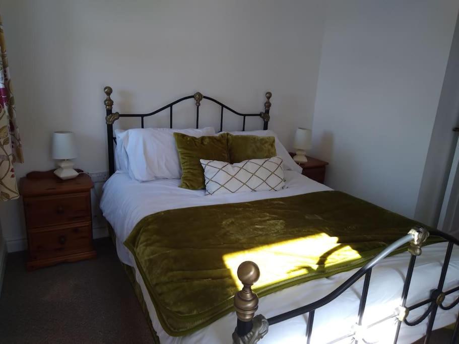 a bedroom with a bed with a green blanket on it at Staycation 3-bedroom home with panoramic views free off road parking in Endon