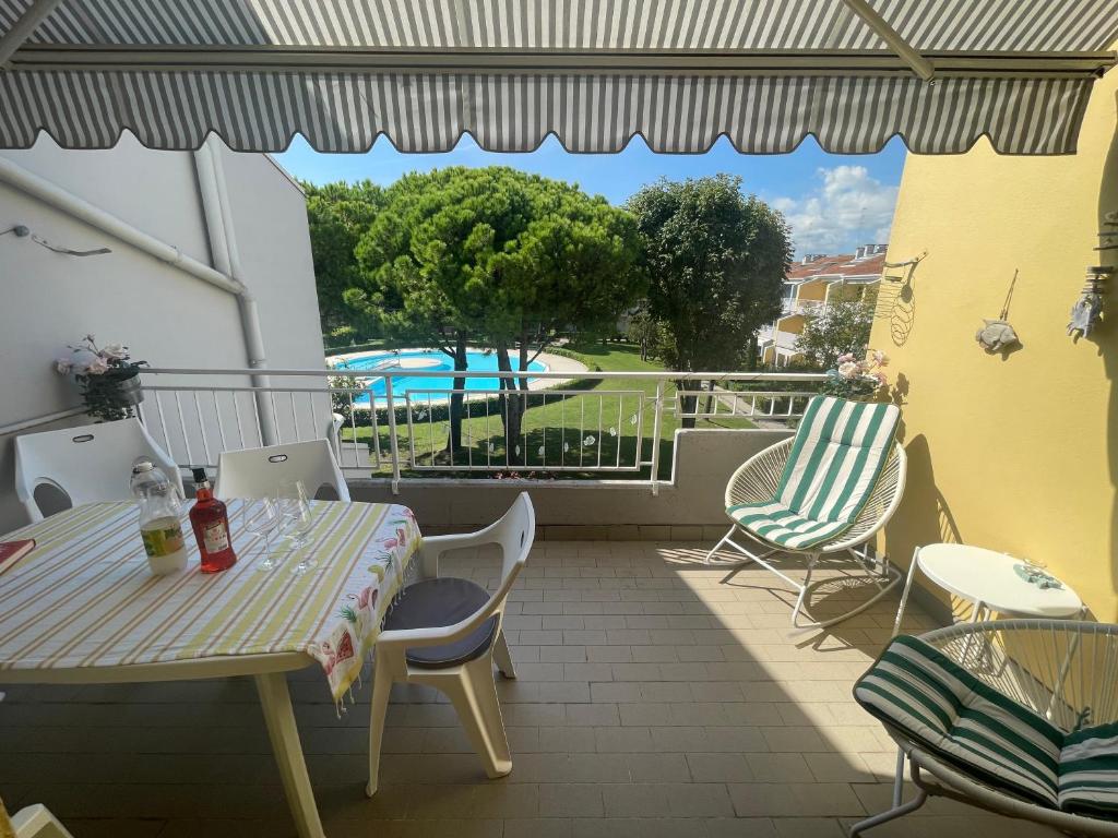 patio con mesa y sillas en el balcón en Villaggio Riviera - Agenzia Cocal, en Caorle
