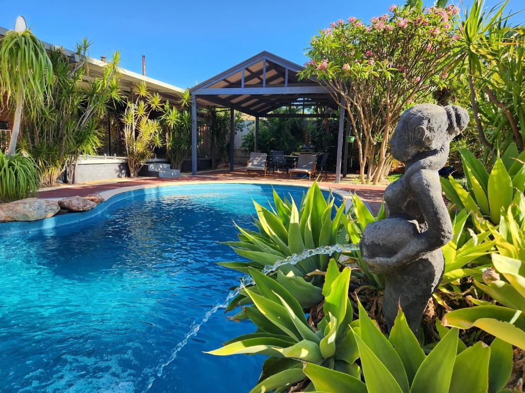 a teddy bear statue next to a swimming pool at Tranquil Gumnut Cottage - Close to Airport in Perth