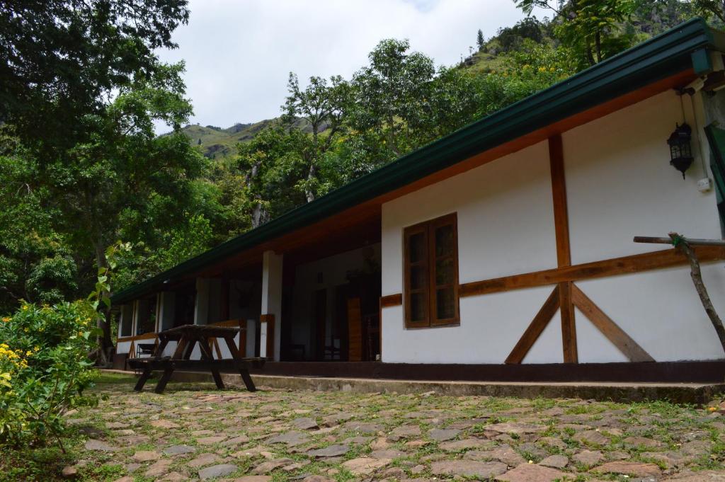 a white house with a table in front of it at The Lodge at Galapitiyaya Estate in Haputale