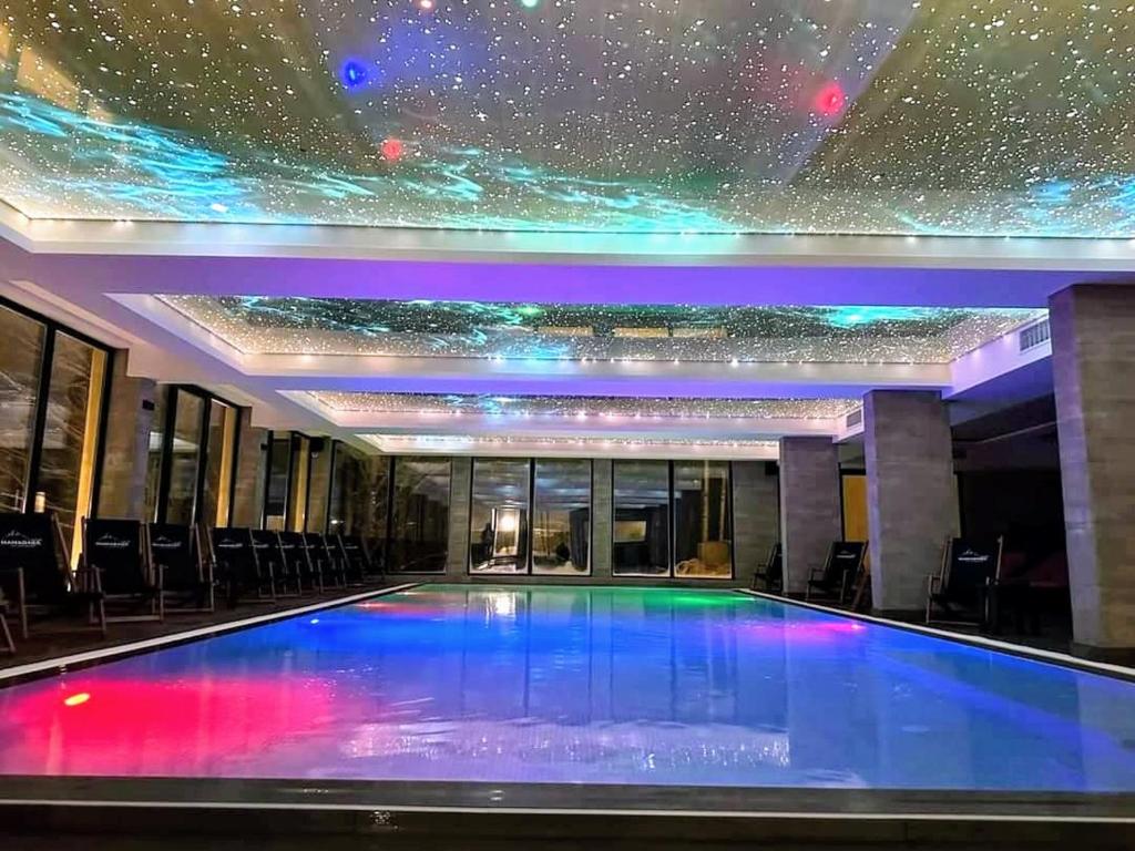 a swimming pool in a building with a star ceiling at Kopaonik Milmari Spa and Wellness Wooden Horn S21 in Kopaonik