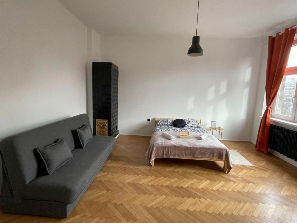 Big and cozy bedroom in Krakow في كراكوف: غرفة معيشة مع أريكة وسرير
