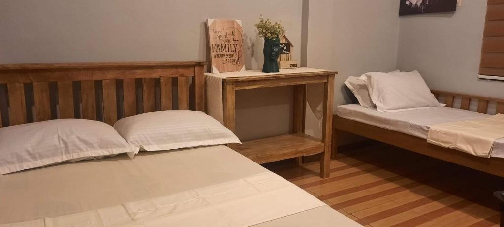 una camera con due letti e un tavolo con di Yana's Place a Donsol
