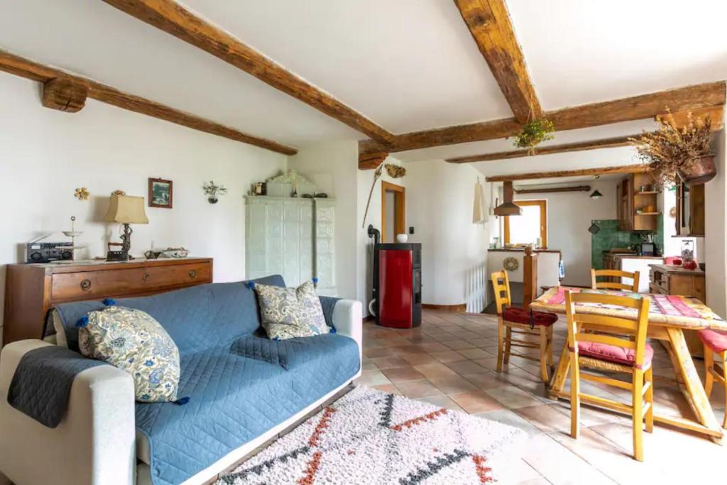 a living room with a blue couch and a table at iRIVAS Lodge in Pellizzano