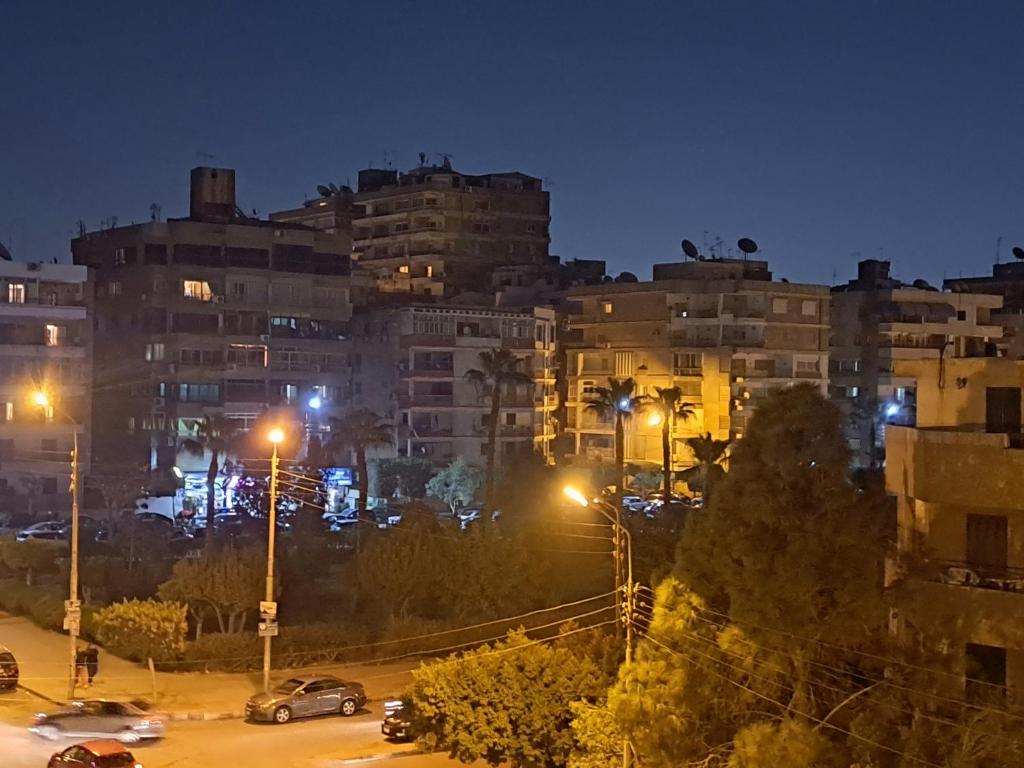 eine Stadt in der Nacht mit Autos auf einem Parkplatz in der Unterkunft Hijaz Street Hotel in Kairo