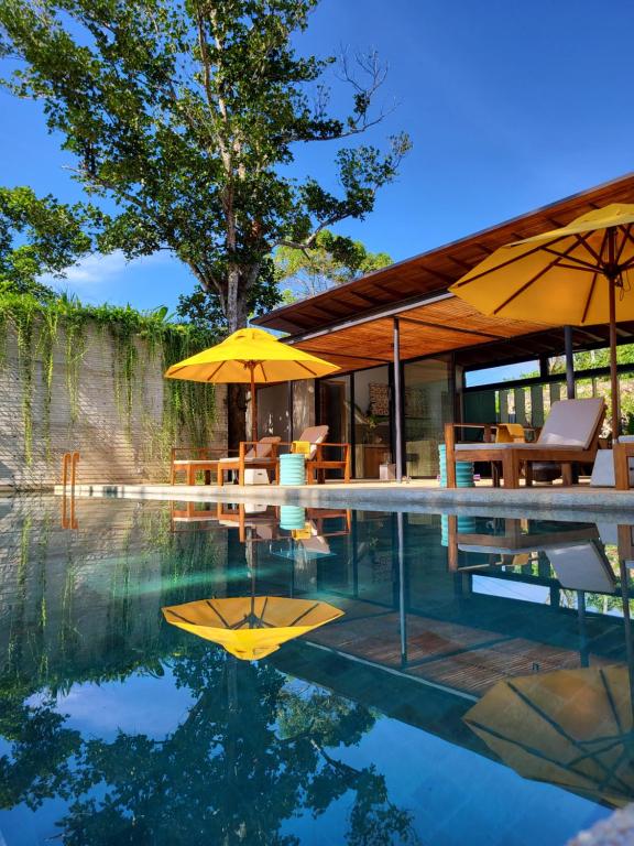una casa con piscina con tavoli e ombrelloni di Villa Alba - Ahangama ad Ahangama