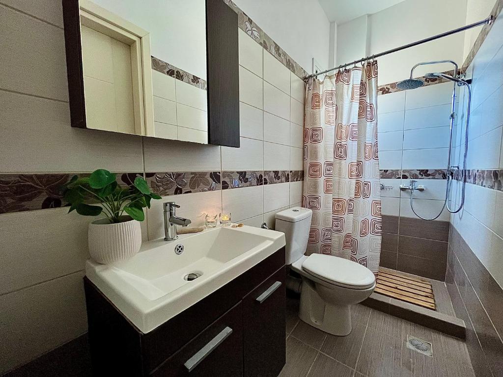 a bathroom with a sink and a toilet and a shower at Dionysis Villas in Skala